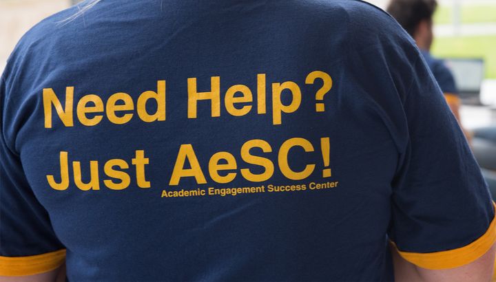 Photo of the AeSC Center tutor shirt with text "Need help? Just AeSC!"