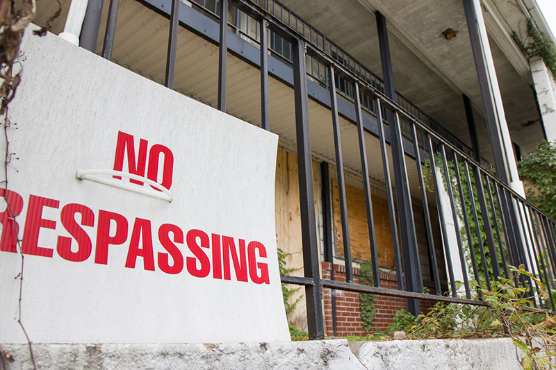 Photo of a city block with a "No Trespassing" sign