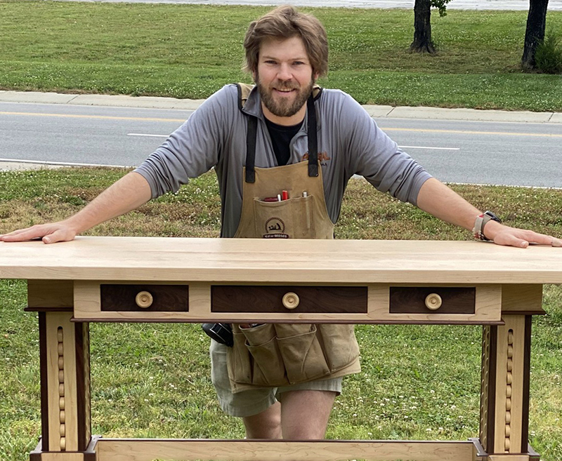 Photo of Perry Ferrell with a desk he built