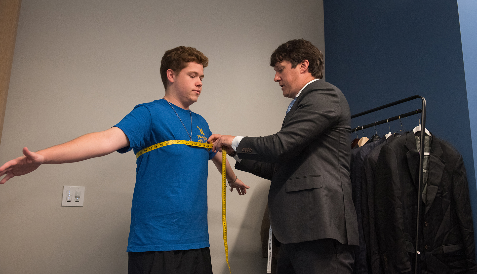 Photo of a student being measured in the Career Closet