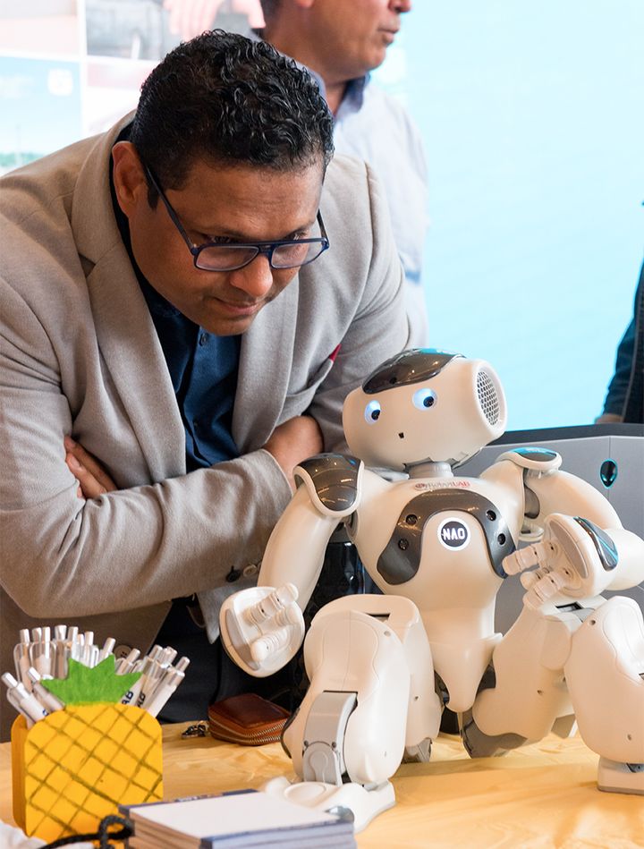 Photo of Ajay Aluri with Nao, the HIT Lab's robot concierge